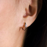 Fine jewellery, silver jewellery, hypoallergenic, tarnish-free, close-up right view of a Silver hoop earrings with embedded stones worn on a person's ear